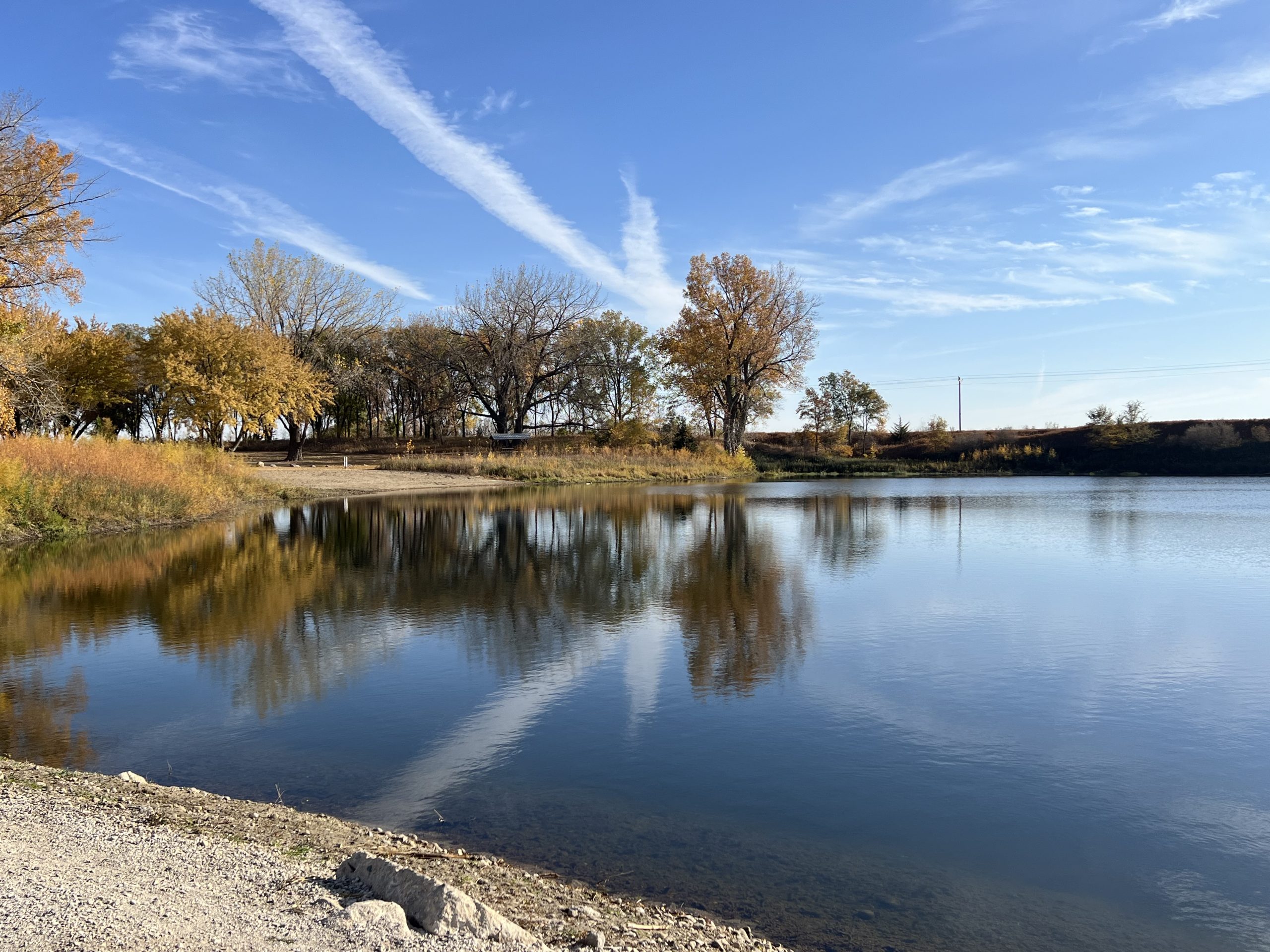 Douma Park showing the clear lake with blue sky and trees.